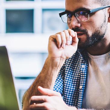 Person with glasses working on computer